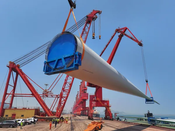 Wind turbine blade lifting with workers on site